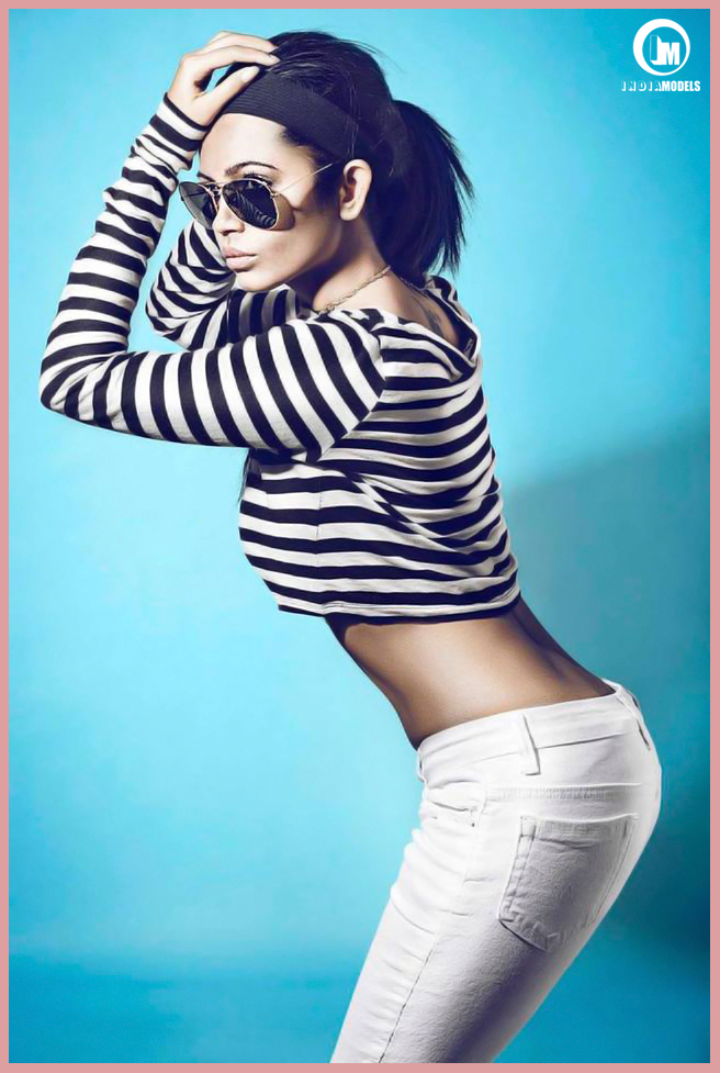 Beautiful Indian model Supriya Boshe wearing white pants with a striped sweater.