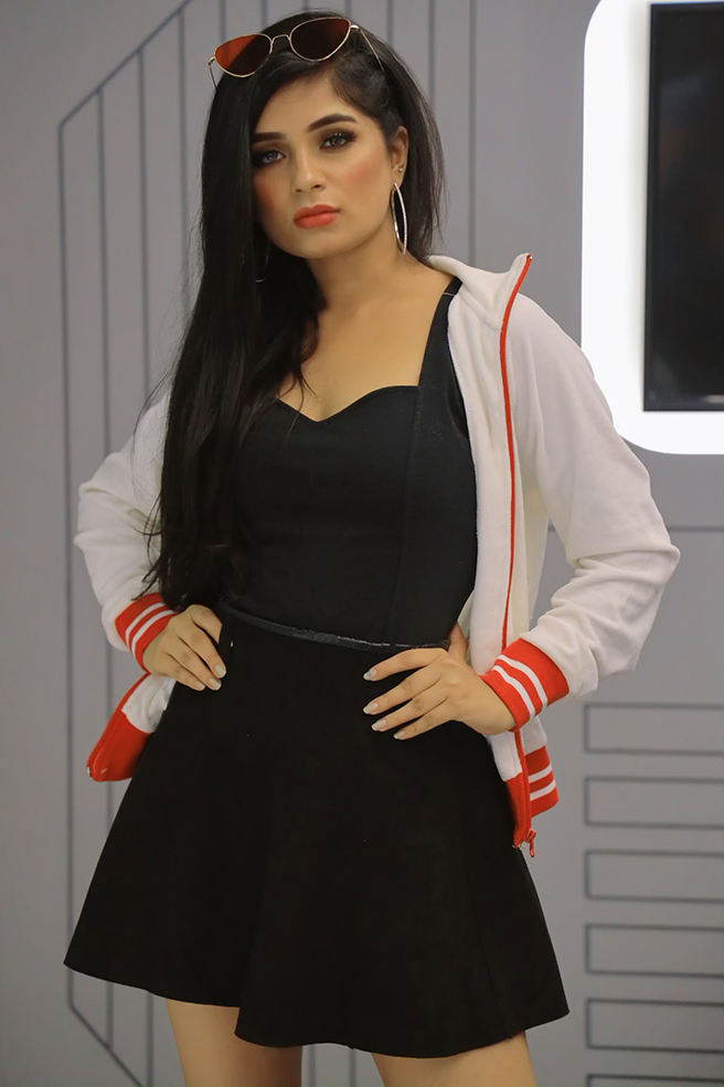 Indian model Aishwarya Adarkar wearing a black dress and a white jacket